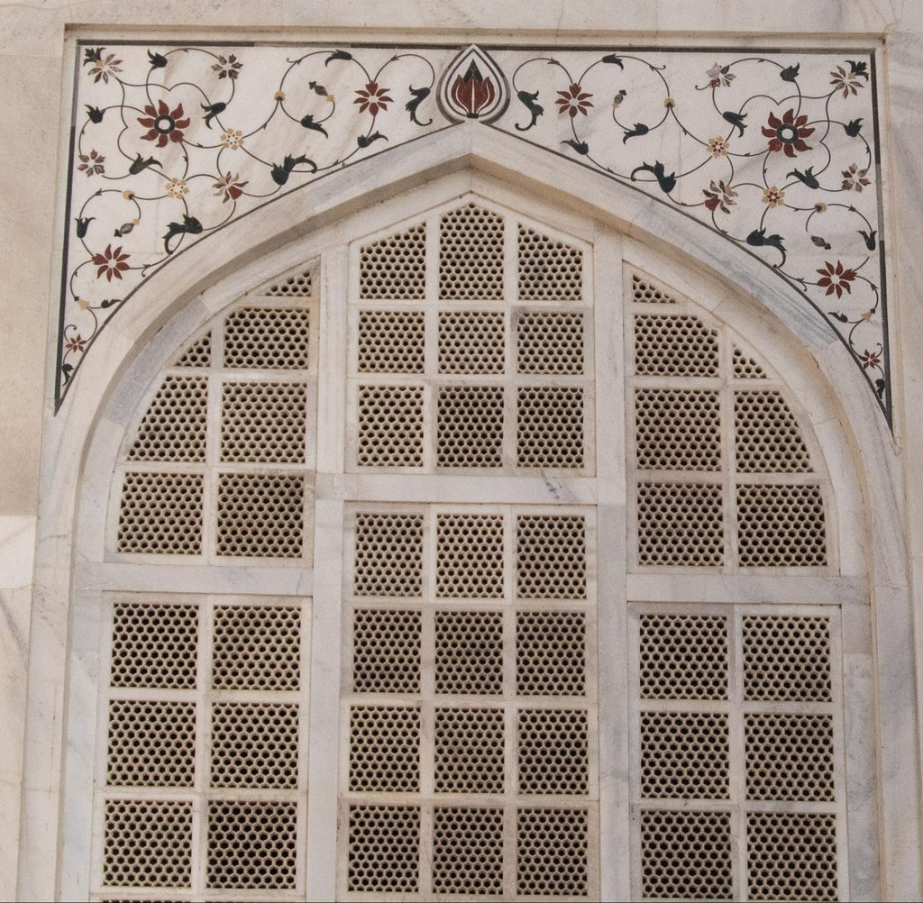 Carved white marble jali lattice screen enclosing the cenotaphs inside the Taj Mahal.