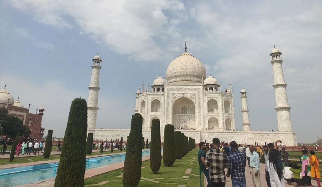 Front view of the Taj Mahal in Agra with gardens and visitors