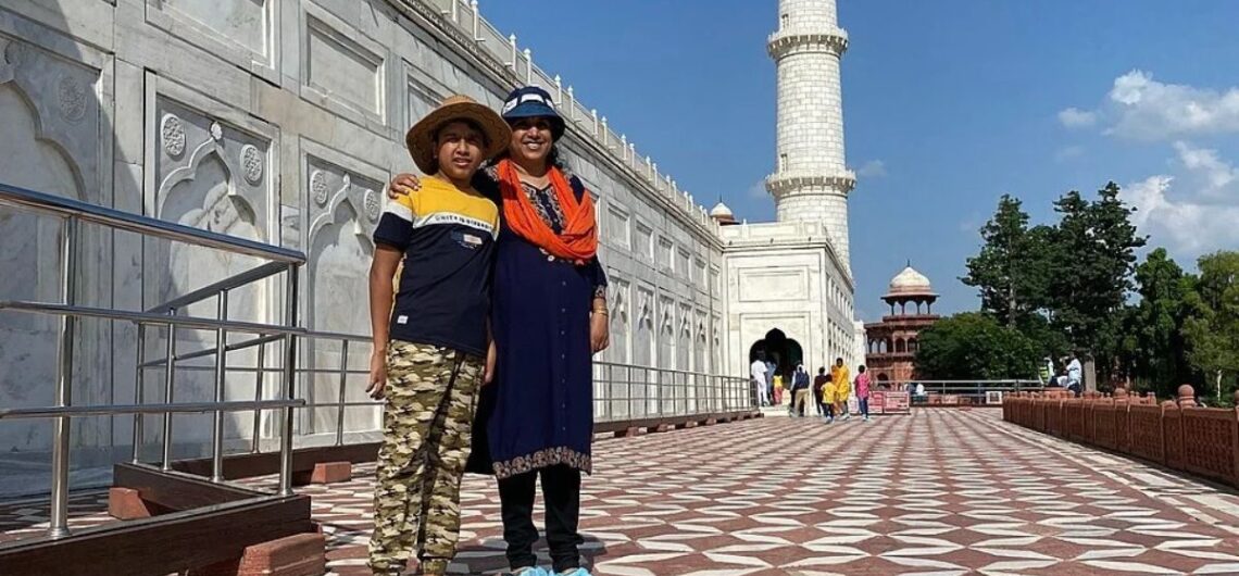 Visitors standing beside the Taj Mahal in Agra